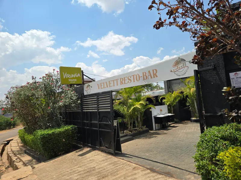 The entrance of Velvett Resto-Bar in Kigali, with its banner over a palm-lined courtyard